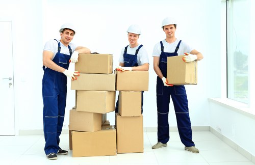 Professional movers carrying furniture down stairs in a Catford property