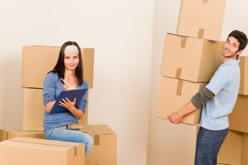 Movers using protective gloves and equipment to safely carry a heavy item