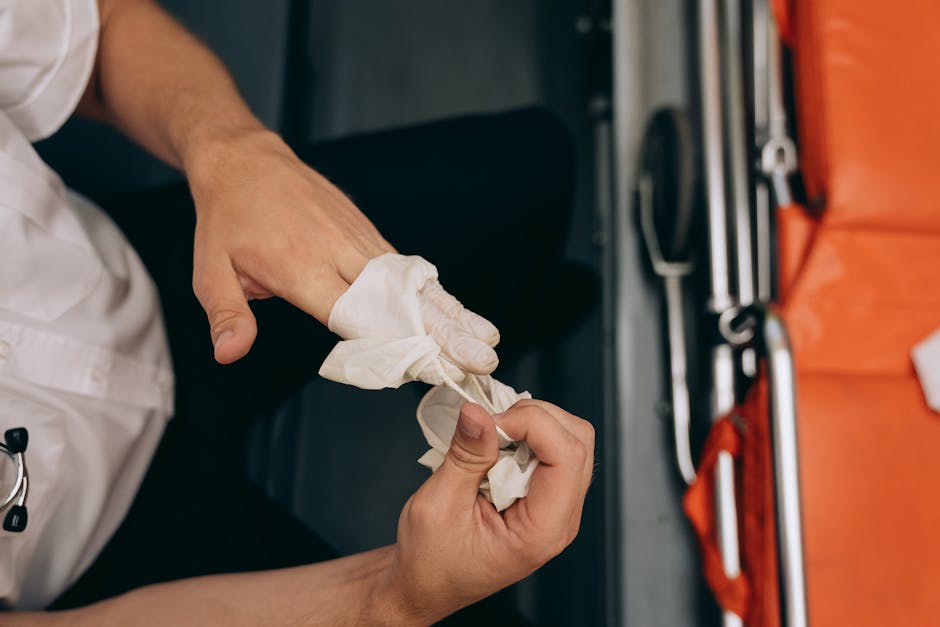 A man wearing a white t-shirt, jeans, and a black cap sits on the edge of a loaded moving van with its rear door open. Inside the van, numerous cardboard boxes of various sizes are arranged, some stac